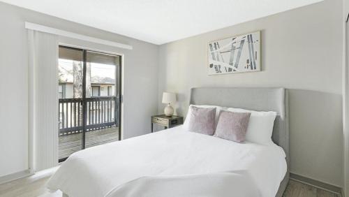 Habitación blanca con cama y ventana en Landing Modern Apartment with Amazing Amenities (ID5970X69) en Huntsville
