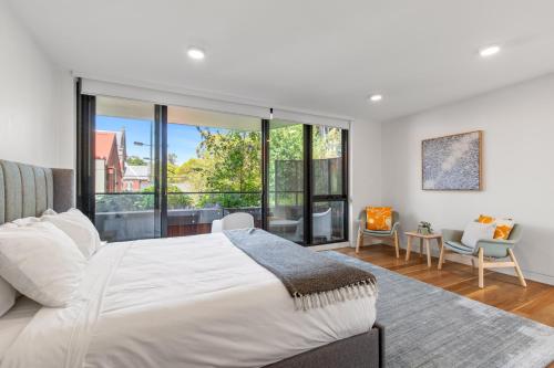 a bedroom with a white bed and a large window at Fantastic 3-Bed Home by Melbourne Uni & Zoo in Melbourne