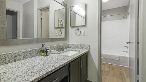 y baño con lavabo, espejo y ducha. en Landing Modern Apartment with Amazing Amenities (ID5970X69) en Huntsville