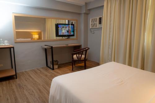 a hotel room with a bed and a television at Cebu Grand Hotel in Cebu City