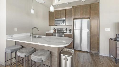 eine Küche mit einer Spüle und einem Kühlschrank in der Unterkunft Landing Modern Apartment with Amazing Amenities (ID1220X094) in Omaha