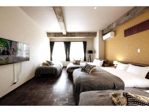 ein Hotelzimmer mit 2 Betten und einem Flachbild-TV in der Unterkunft Volcano - Vacation STAY 89674 in Kagoshima