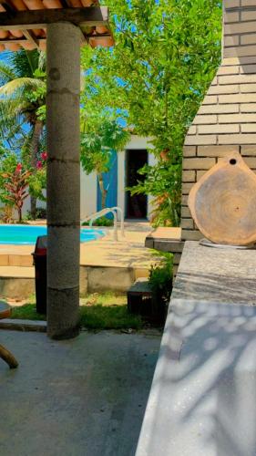 a table with a wooden bench next to a pool at Casa em Mundaú Trairi-Ce in Trairi