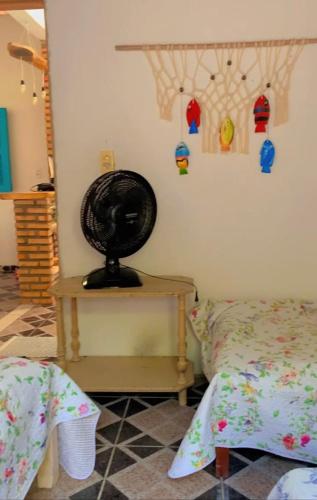 a bedroom with a bed and a fan on a table at Casa em Mundaú Trairi-Ce in Trairi