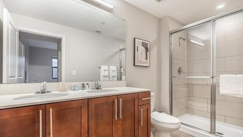 ein Bad mit einem WC, einem Waschbecken und einer Dusche in der Unterkunft Landing Modern Apartment with Amazing Amenities (ID8214X04) in Fort Myers