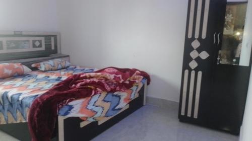 een slaapkamer met een bed met een deken erop bij Hotel Kota kitchen INN and restaurant. in Kota
