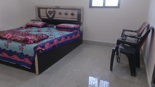 - une chambre avec un lit et une chaise dans l'établissement Hotel Kota kitchen INN and restaurant., à Kota