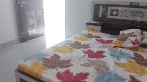 een bed met een dekbed met bladeren erop bij Hotel Kota kitchen INN and restaurant. in Kota