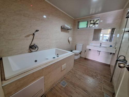 a bathroom with a tub and a toilet and a sink at Xinghe Motel - Chaozhou in Chaozhou