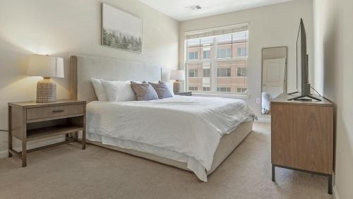 Habitación blanca con cama y TV en Landing Modern Apartment with Amazing Amenities (ID7965X79), en Leesburg