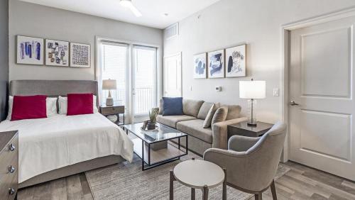 a bedroom with a bed and a couch and a table at Landing Modern Apartment with Amazing Amenities (ID9874X53) in Dallas