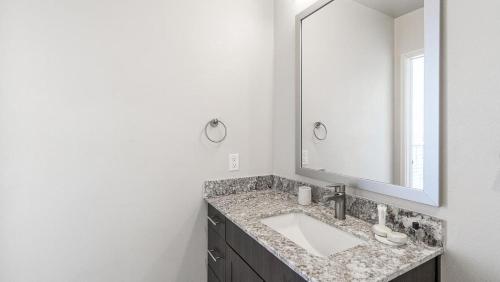 a bathroom with a sink and a mirror at Landing Modern Apartment with Amazing Amenities (ID9874X53) in Dallas