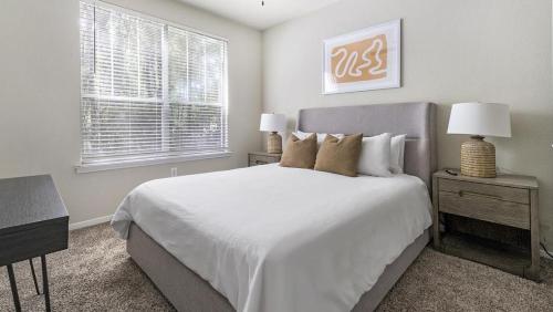 1 dormitorio con 1 cama blanca grande y escritorio en Landing Modern Apartment with Amazing Amenities (ID1337X194), en The Woodlands