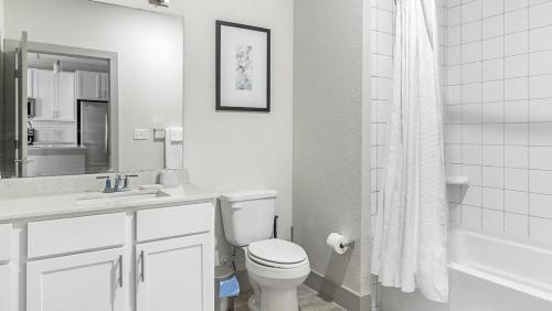 a white bathroom with a toilet and a sink at Landing Modern Apartment with Amazing Amenities (ID1374X218) in San Antonio