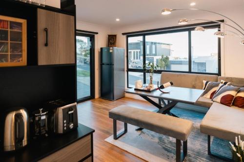 a kitchen and living room with a table and a refrigerator at Ayubo in Apollo Bay
