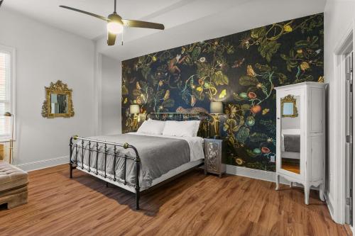 ニューオーリンズにあるStunning 2-Bedroom Garden District Newly Renovatedの大きな絵画が壁に描かれたベッドルーム