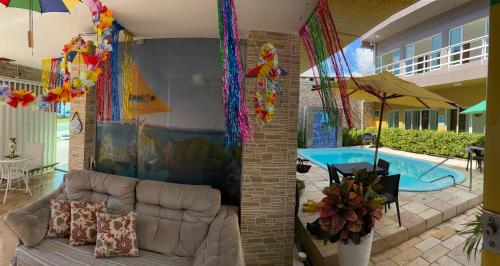 a living room with a couch and a swimming pool at Pousada Residência dos Sonhos in Porto De Galinhas