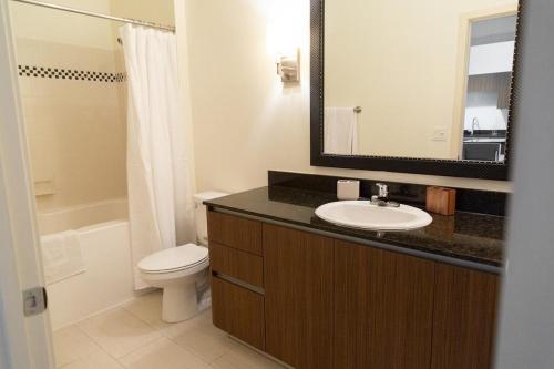 y baño con lavabo, aseo y espejo. en Landing Modern Apartment with Amazing Amenities (ID3353), en Tampa
