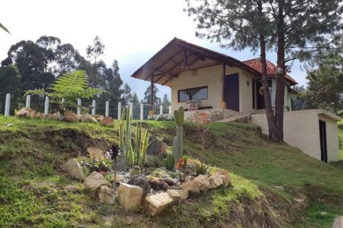 a house on top of a hill with a garden at Linda mini casa campestre con Jacuzzi, chimenea... in Paipa