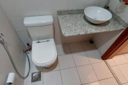 uma casa de banho com um WC branco e um lavatório. em Studio aconchegante no coração do centro do RJ. no Rio de Janeiro