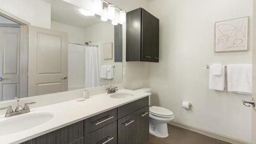 y baño con lavabo, aseo y espejo. en Landing Modern Apartment with Amazing Amenities (ID1230X535), en San Antonio