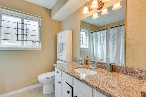 La salle de bains est pourvue d'un lavabo, de toilettes et d'un miroir. dans l'établissement Quiet Houston Home with Porch - 6 Mi to NRG Stadium!, à Houston