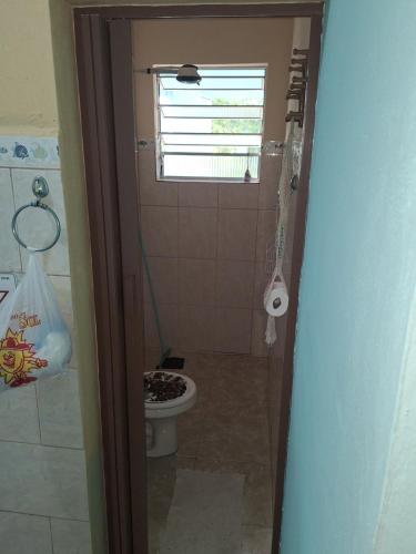 a bathroom with a toilet and a window at POUSADA BORBOLETA AZUL in Ilha Comprida