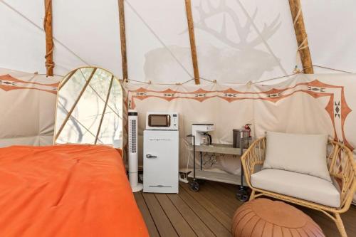 Stanton的住宿－Furnished Teepee/Glamping/Kayak Ramp/King Bed，帐篷内的房间,配有一张床和椅子
