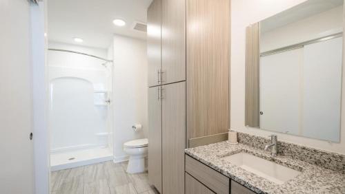 a bathroom with a sink and a toilet and a mirror at Landing Modern Apartment with Amazing Amenities (ID8194X48) in Birmingham