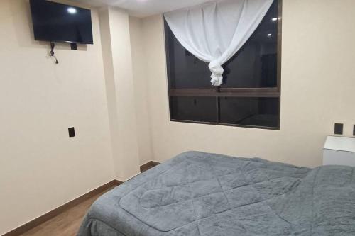 een slaapkamer met een bed en een raam bij mono ambiente independiente (5) in Sucre
