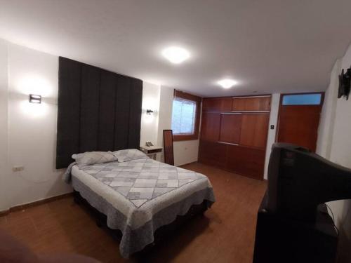 - une chambre avec un lit et une télévision dans l'établissement Duplex LOFT. céntrico a unas cuadras de Recoleta, à Cajamarca