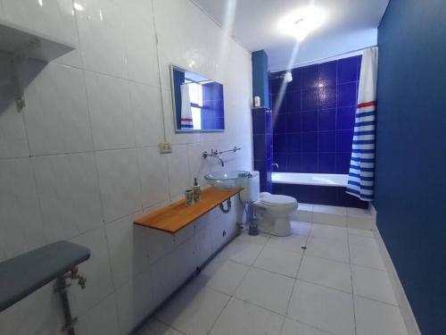 La salle de bains bleue et blanche est pourvue d'un lavabo et de toilettes. dans l'établissement Duplex LOFT. céntrico a unas cuadras de Recoleta, à Cajamarca