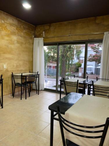 un restaurante con mesas y sillas y una gran ventana en Posada del Lago en Villa Carlos Paz