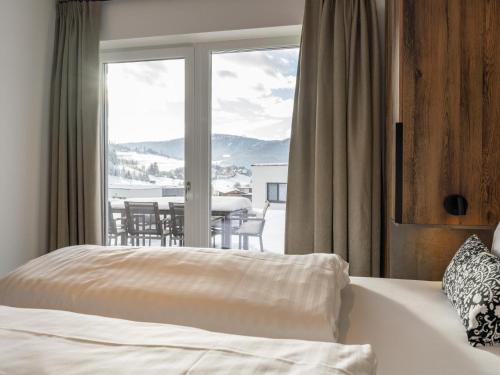 a bedroom with a bed and a view of a table at Grebenzen Lodge Pabstin 36B in Sankt Lambrecht