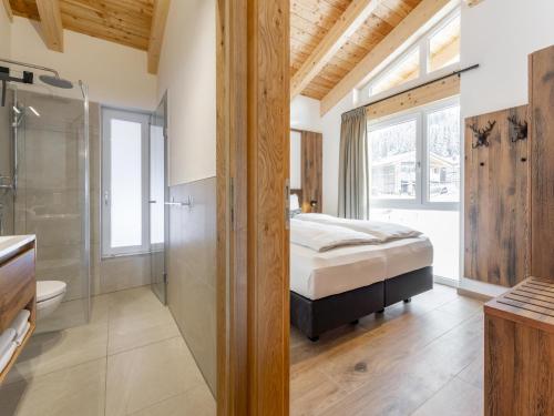 um quarto com uma cama king-size e um chuveiro em Grebenzen Lodge Pabstin 36B em Sankt Lambrecht