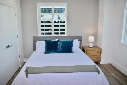 - une chambre avec un lit doté d'oreillers bleus et d'une fenêtre dans l'établissement Landing Modern Apartment with Amazing Amenities (ID2666X16), à Fort Lauderdale