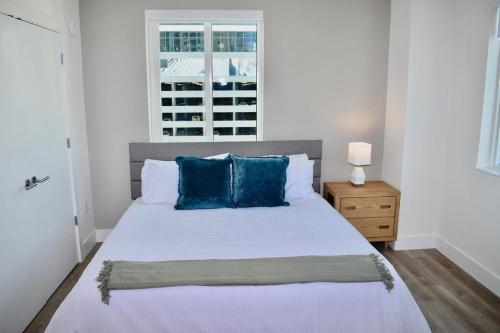 a bedroom with a bed with blue pillows and a window at Landing Modern Apartment with Amazing Amenities (ID2666X16) in Fort Lauderdale