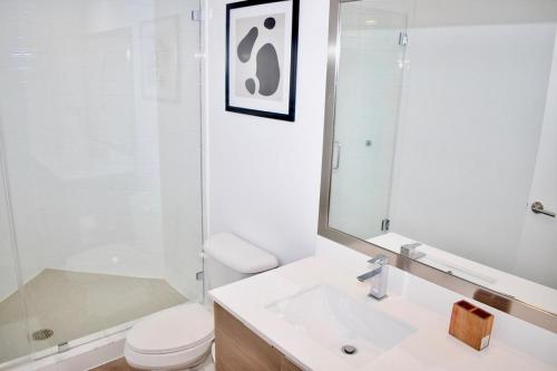 y baño con aseo, lavabo y espejo. en Landing Modern Apartment with Amazing Amenities (ID2666X16) en Fort Lauderdale