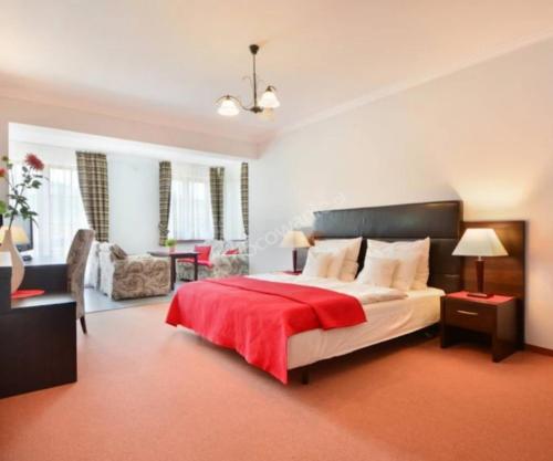 sypialnia z dużym łóżkiem i czerwonym kocem w obiekcie Apartament CALMA & SPA w Kudowie Zdroju