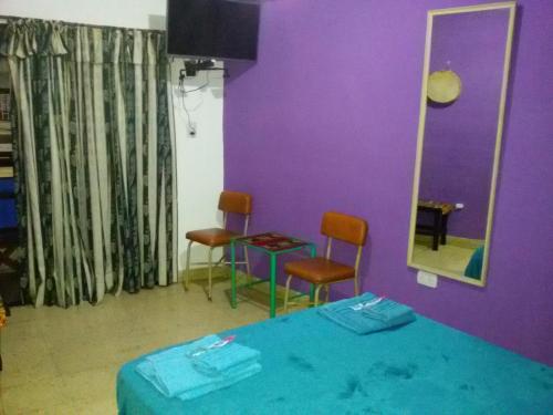 um quarto com uma cama e duas cadeiras e um espelho em Tacita de Plata Apart em San Salvador de Jujuy