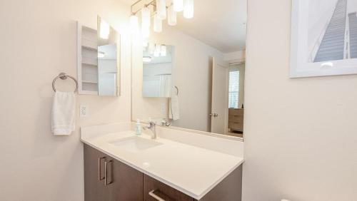 y baño con lavabo y espejo. en Landing Modern Apartment with Amazing Amenities (ID6801) en West Sacramento
