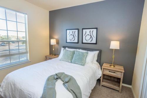 een slaapkamer met een groot wit bed en 2 lampen bij Landing Modern Apartment with Amazing Amenities (ID6446) in Brandon