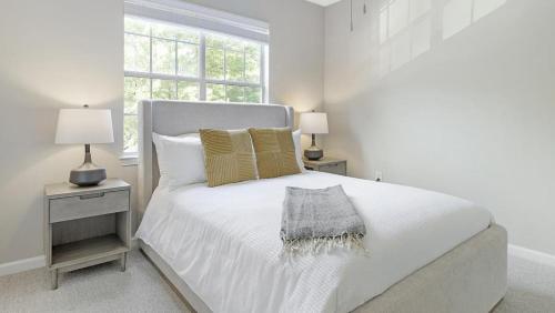 a white bedroom with a bed and two lamps at Landing Modern Apartment with Amazing Amenities (ID1192X939) in Duluth