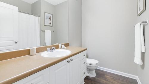 a white bathroom with a sink and a toilet at Landing Modern Apartment with Amazing Amenities (ID1192X939) in Duluth