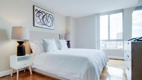 a white bedroom with a white bed and a window at Landing Modern Apartment with Amazing Amenities (ID2805X39) 