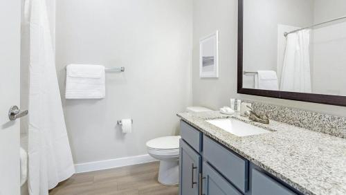 a bathroom with a toilet and a sink and a mirror at Landing Modern Apartment with Amazing Amenities (ID1206X872) in San Marcos