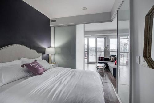 een slaapkamer met een groot bed met een paars kussen bij CN lovers in Toronto