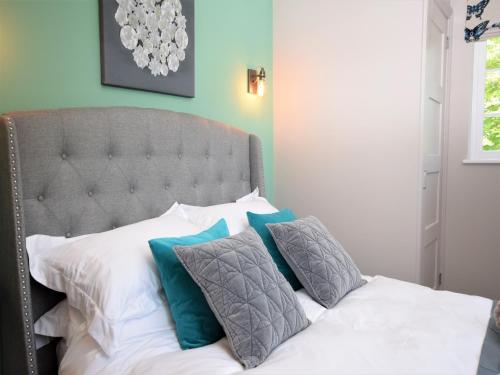 a bed with white and blue pillows on it at 1 Bed in Upper Brailes 57103 in Upper Brailes