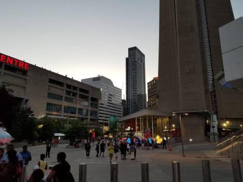 a group of people walking around in a city at CN lovers in Toronto