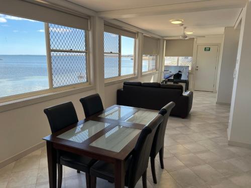 una sala de estar con mesa y sillas y el océano en Beachside & Jetty View Apartment 5 - Harbour Master Apt, en Streaky Bay